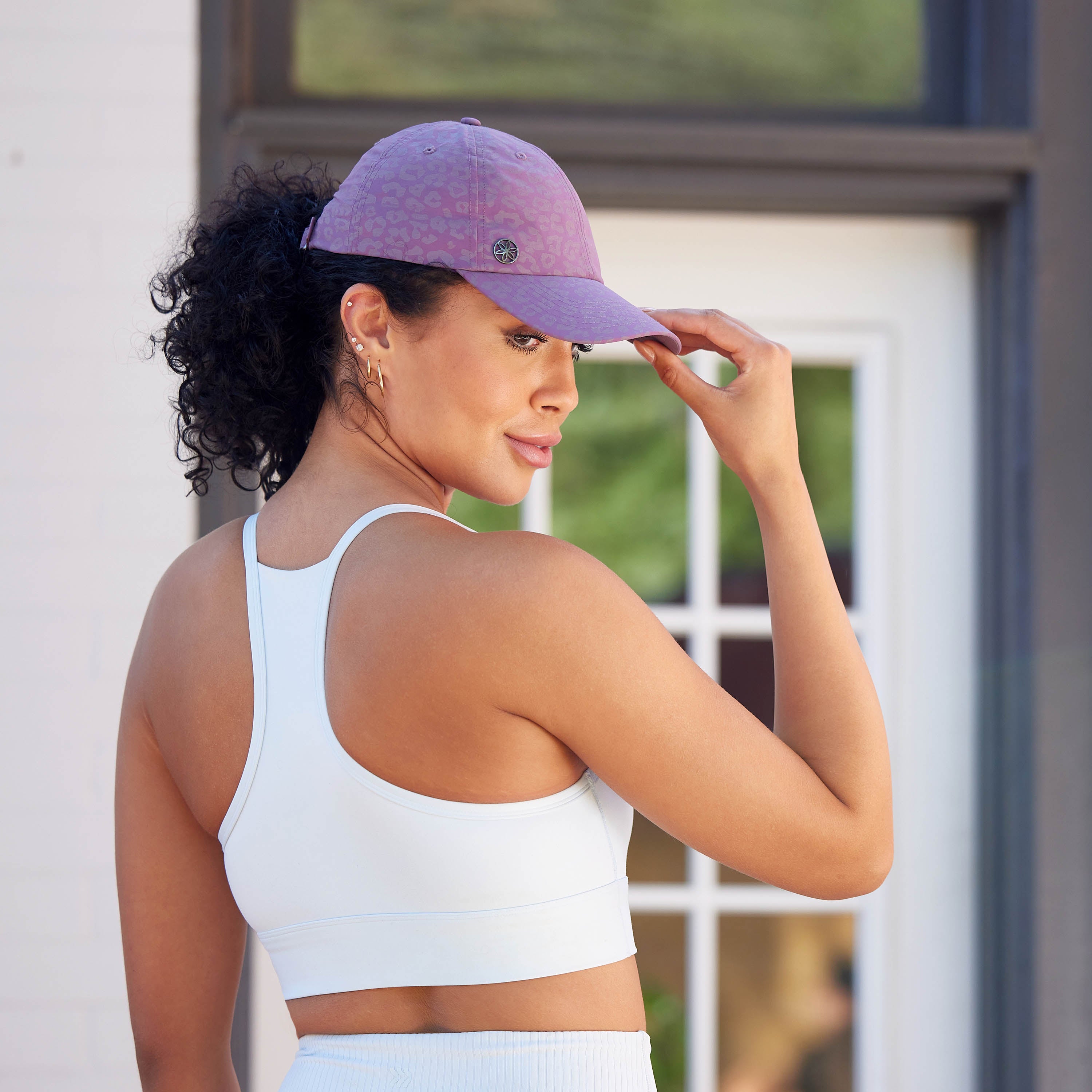 Person wearing the Classic Leopard Print Hat from a side view - hand on the bill of the hat